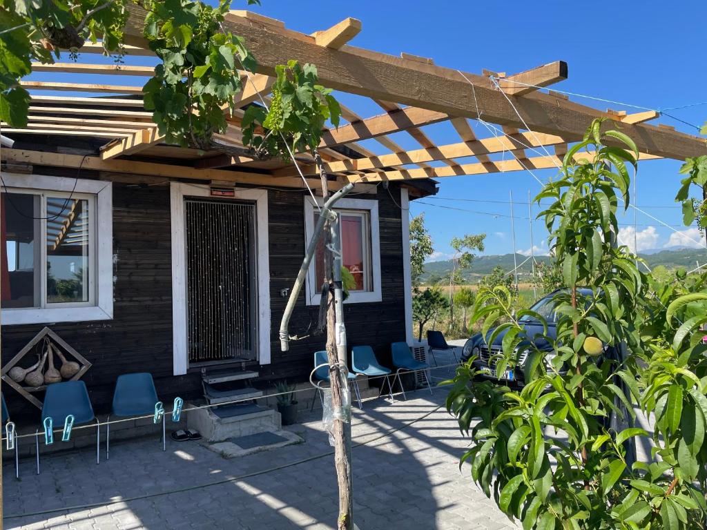 ein Haus mit Pergola und Stühlen auf einer Terrasse in der Unterkunft Ohel in Mullini i Danit