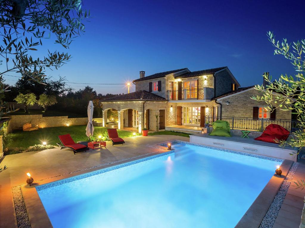 a swimming pool in front of a house at Splendid Villa with Private Swimming Pool in Baderna