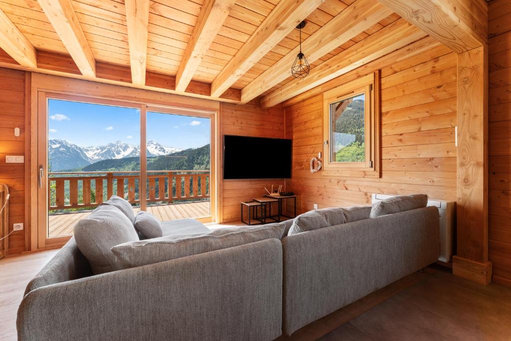a living room with a couch and a large window at Les chalets Super Geants in Saint-François-Longchamp