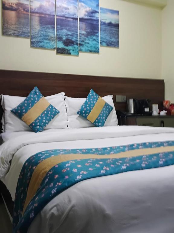 a bedroom with a bed with four paintings on the wall at Tourist Inn in Male City