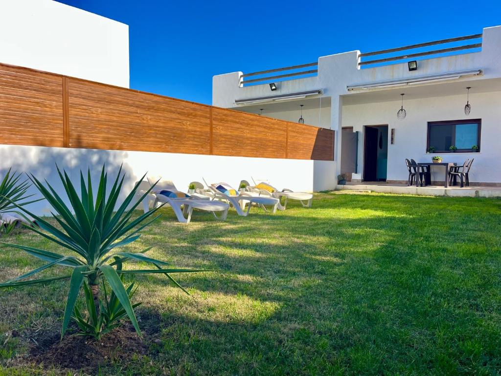 a group of chairs sitting outside of a building at Casa Poniente, encantadora casa de 2 dormitorios con jardín in Zahora