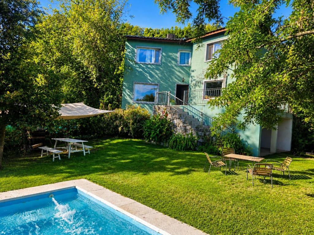 a backyard with a swimming pool and a house at Casa Verde in La Cumbre