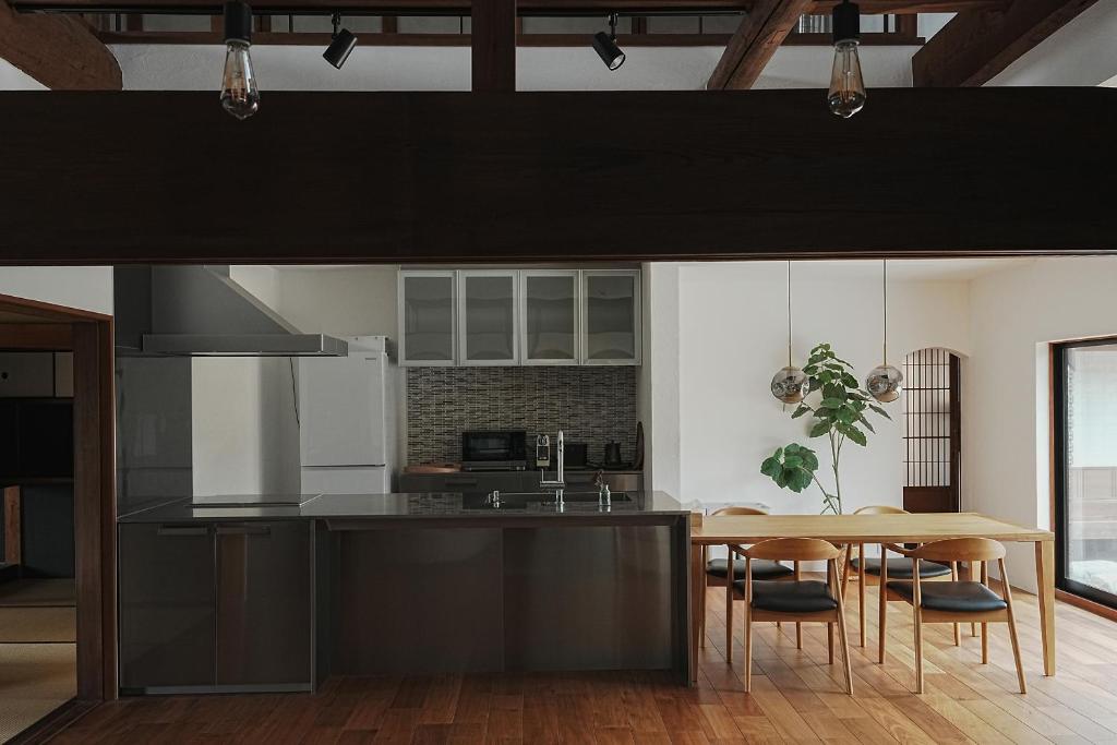a kitchen with a wooden table and a dining room at TOKIWA葛城-katsuragi- in Shinjō
