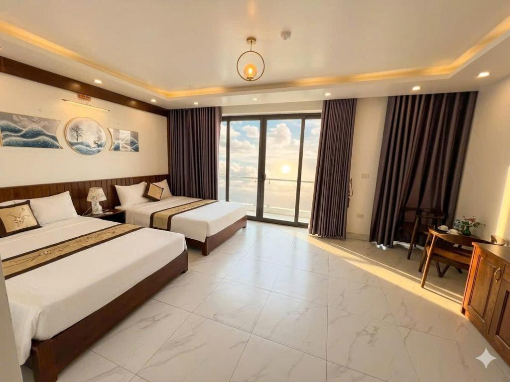 a hotel room with two beds and a large window at Khách Sạn Moonlight FLC Sầm Sơn in Sầm Sơn