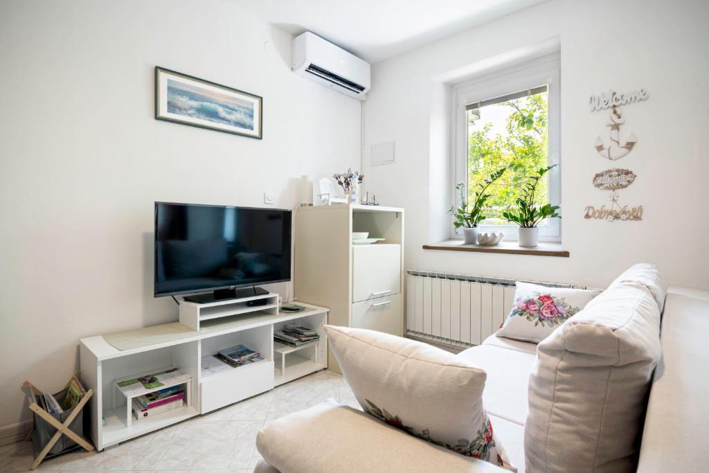 a living room with a couch and a tv at Apartment Gorgo in Sečovlje