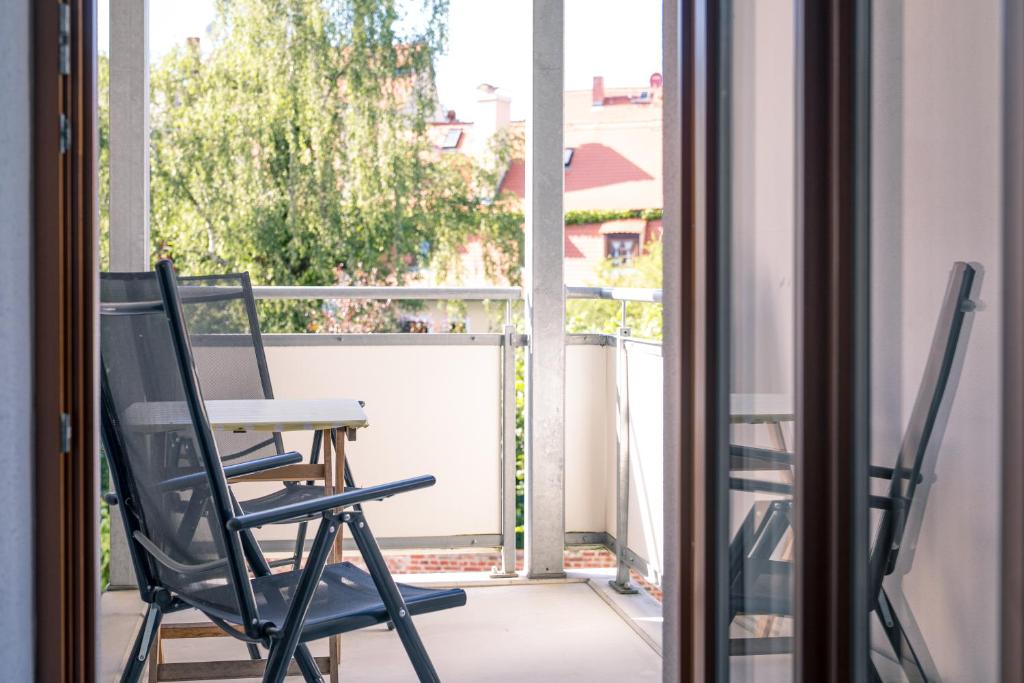 a balcony with a table and two chairs on a porch at Gästehaus Am Hothertor in Görlitz