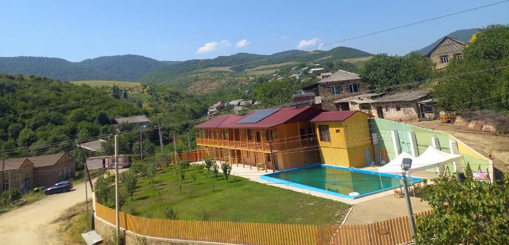 a house with a swimming pool on a hill at Ani Center Hotel in Dovekh