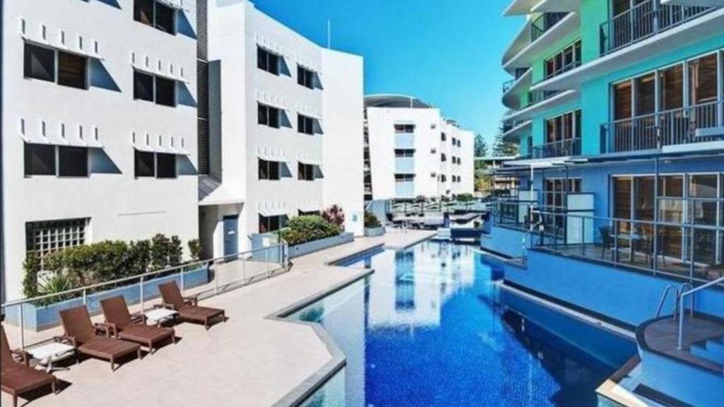 a swimming pool in front of some buildings at Rolling Surf Resort Unit 48 in Caloundra