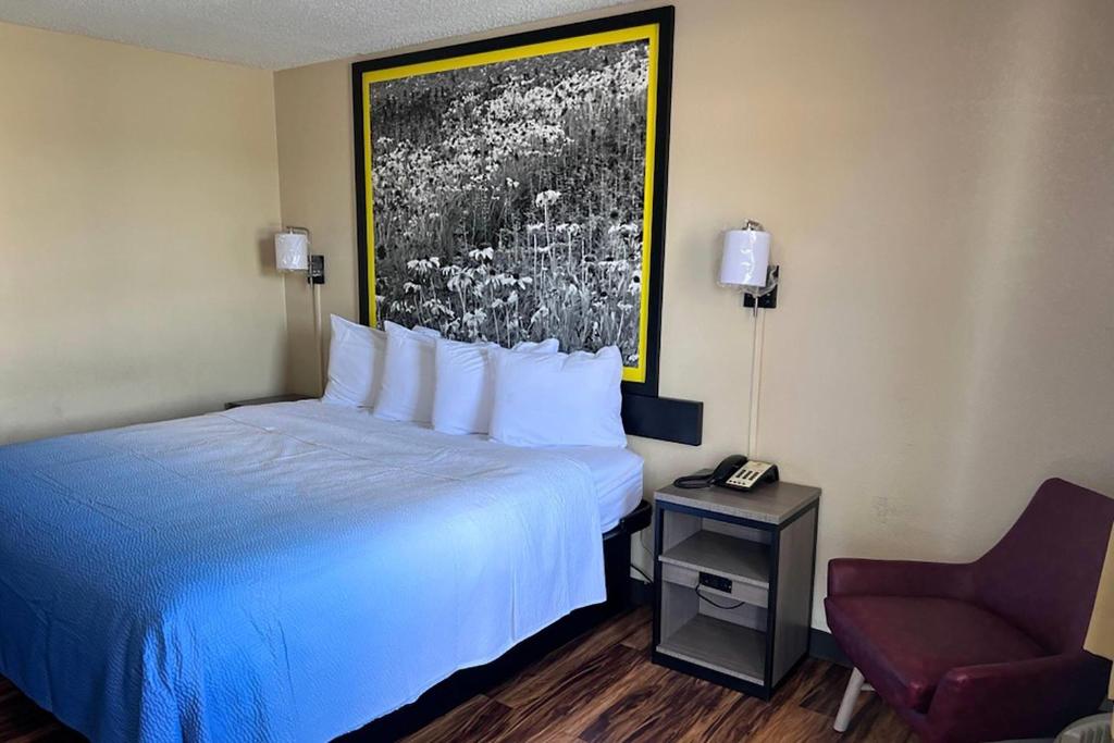 a hotel room with a bed and a chair at Super 8 by Wyndham Lumberton NC in Lumberton