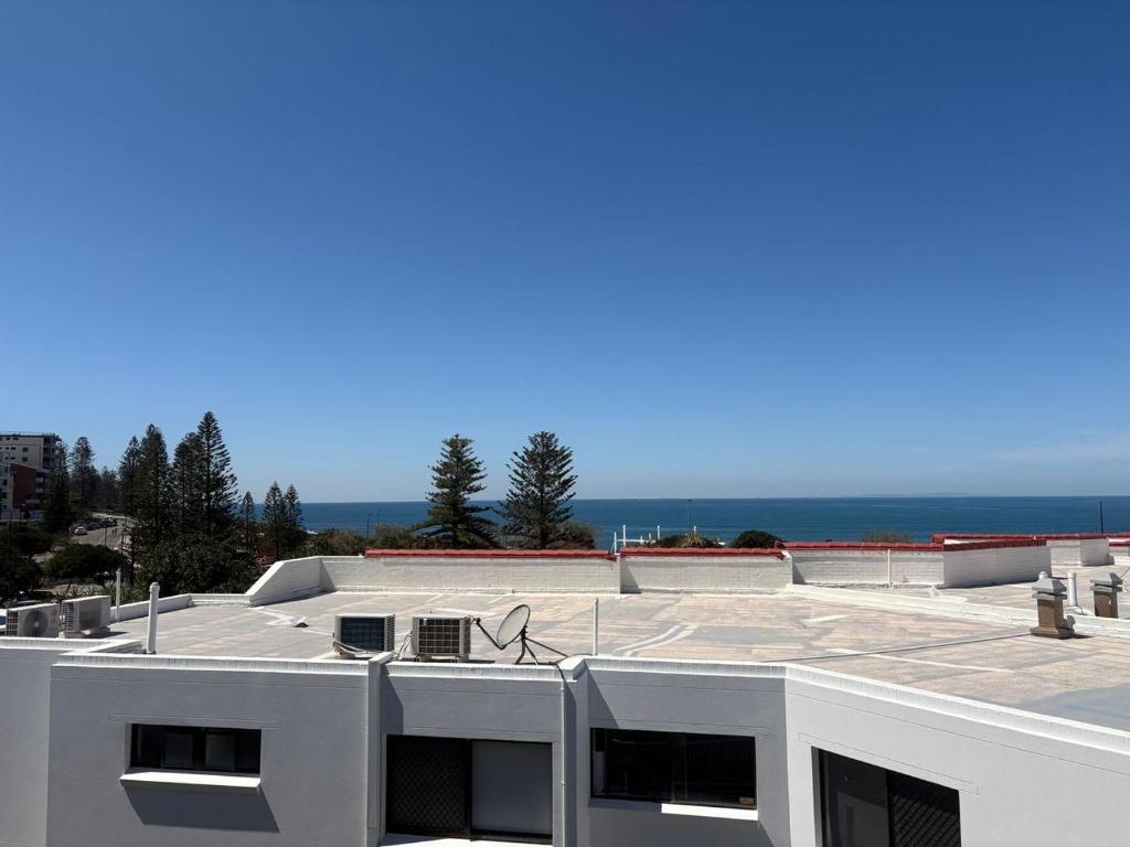 a white building with the ocean in the background at Spinnaker Seas Unit 8 in Caloundra