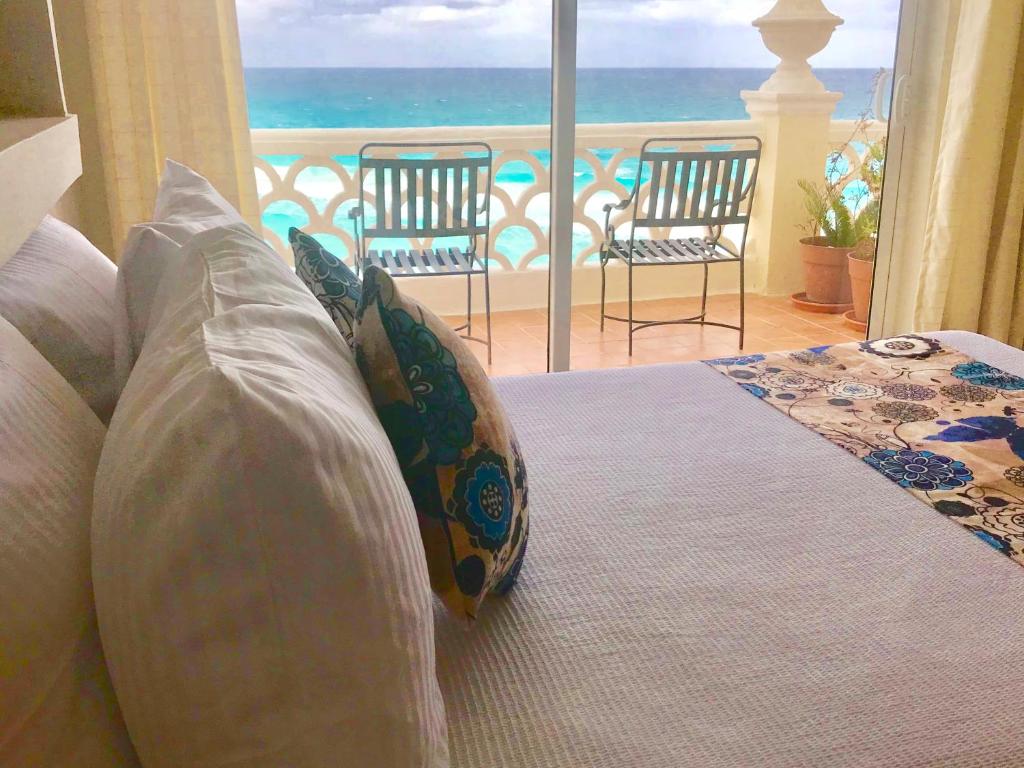 a couch with pillows and a view of the ocean at Ventanas al Paraiso Apartment Cancun in Cancún