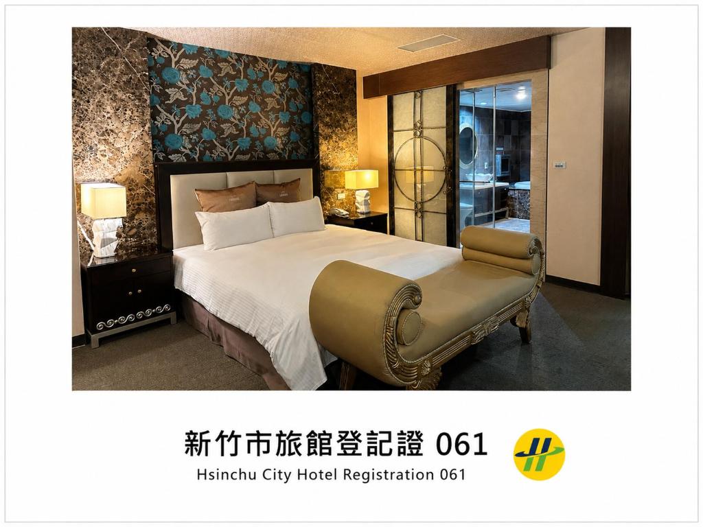 a hotel room with a large bed and a chair at Crystal Business Motel in Hsinchu City