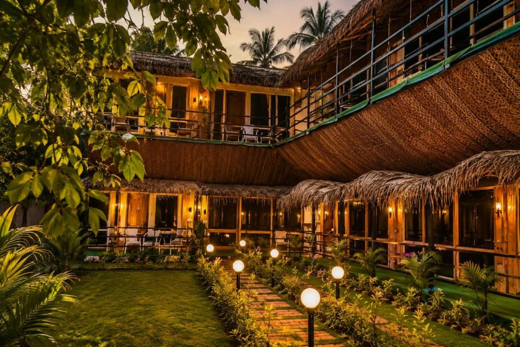 an exterior view of a resort with lights and trees at Basera At Palolem in Canacona