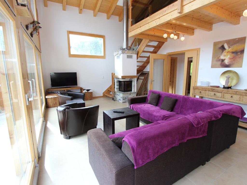 ラ・ズマにあるCharming chalet in La Tzoumaz with open fireplaceのリビングルーム(紫色のソファ、テレビ付)