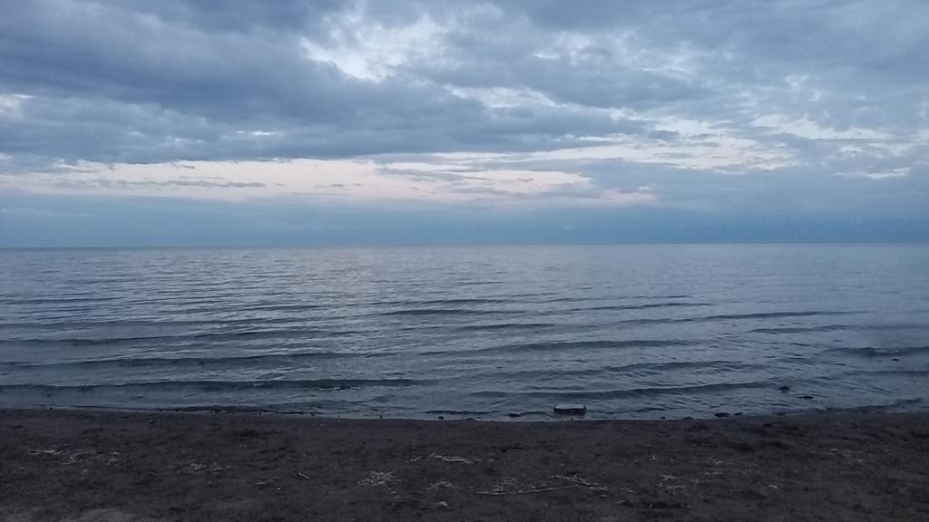 a large body of water with a cloudy sky at Кафе Кочевник in Chon-Sary-Oy
