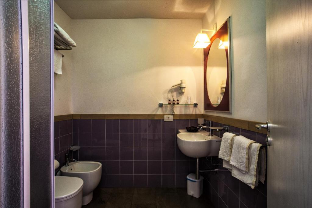 a bathroom with two sinks and a toilet and a mirror at Hotel O'scià in Lampedusa