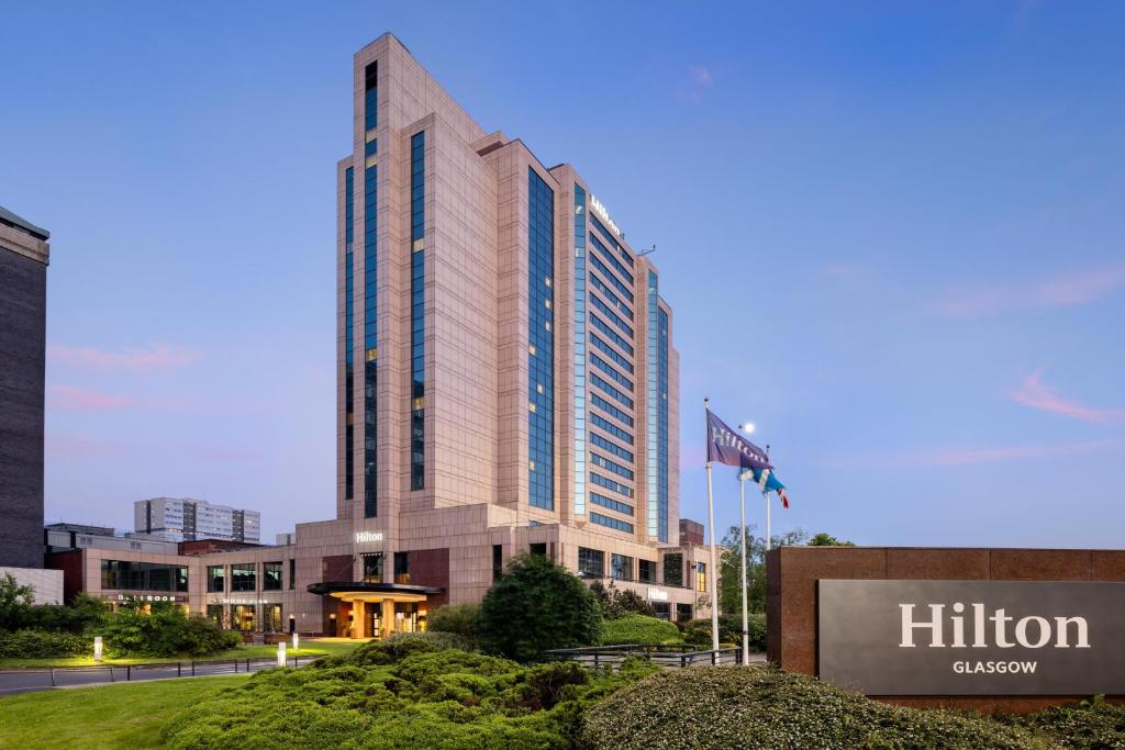 a tall building with a sign in front of it at Hilton Glasgow in Glasgow