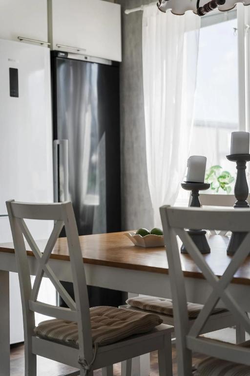a kitchen with a wooden table and two chairs at Private Villa with parking - Skellefteå in Skellefteå