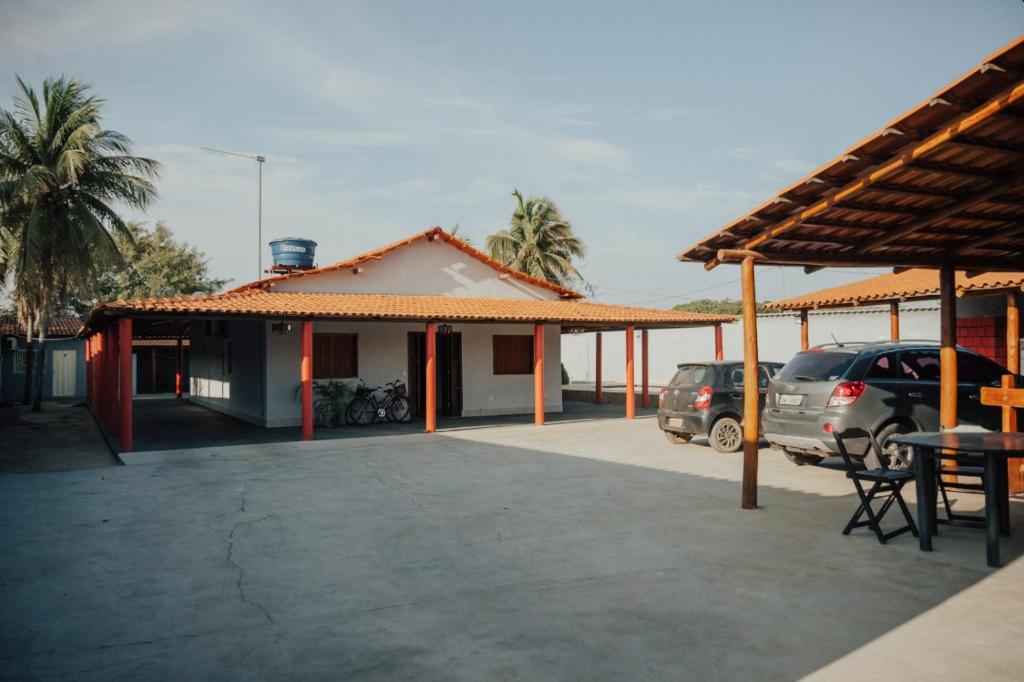 a building with cars parked in a parking lot at Aconchego do Peruaçu in Itacarambi