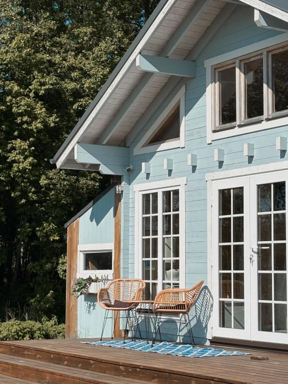 a blue house with two chairs on a deck at Mereäärne helesinine suvemaja in Tahkuranna