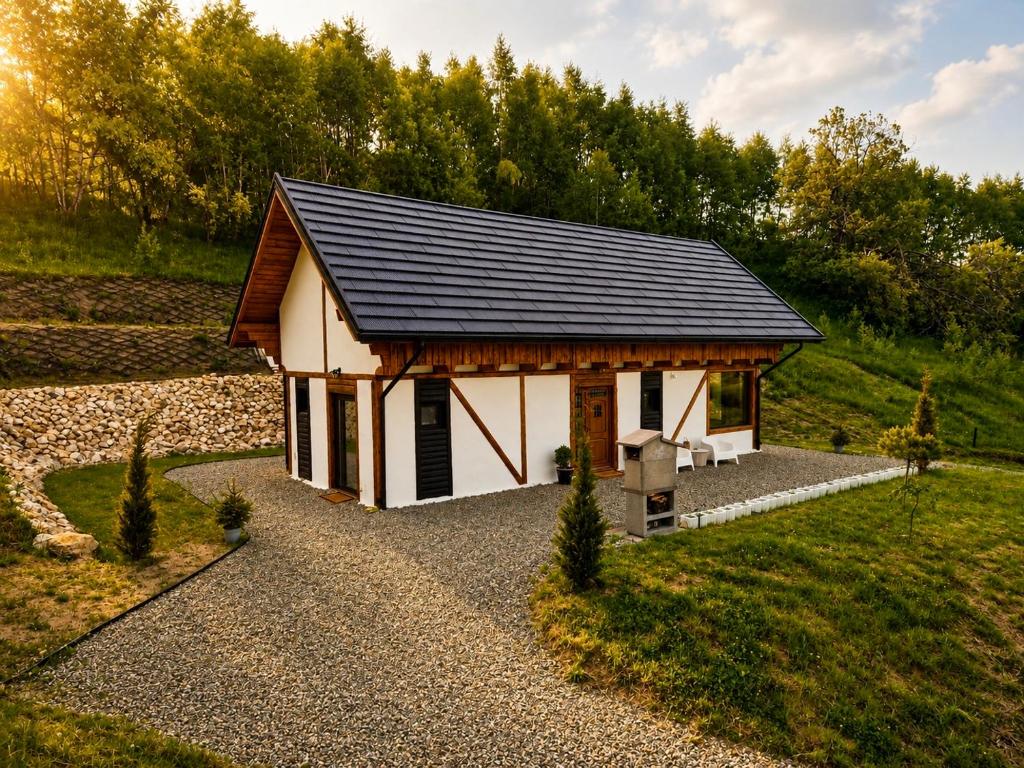 a small house with a black roof at The White House Tripsylvania in Şirnea