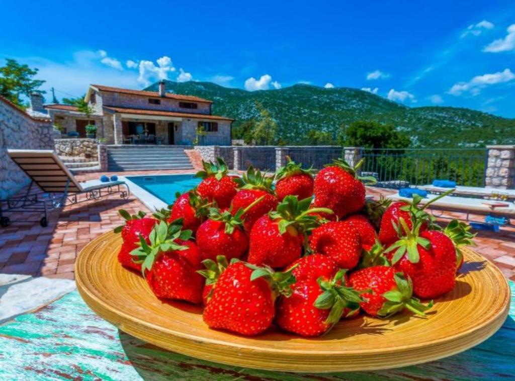 a pile of strawberries on a plate on a table at Rustic Haven Villa in Vrgorac