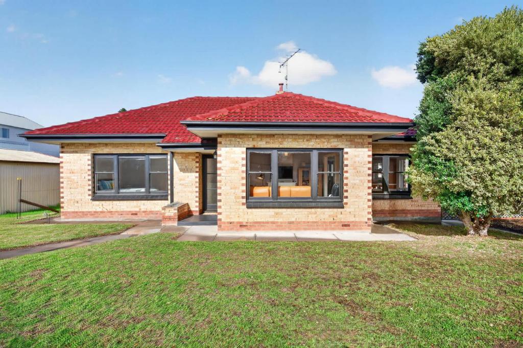 a house with a red roof and a yard at Hutchinson House in Goolwa