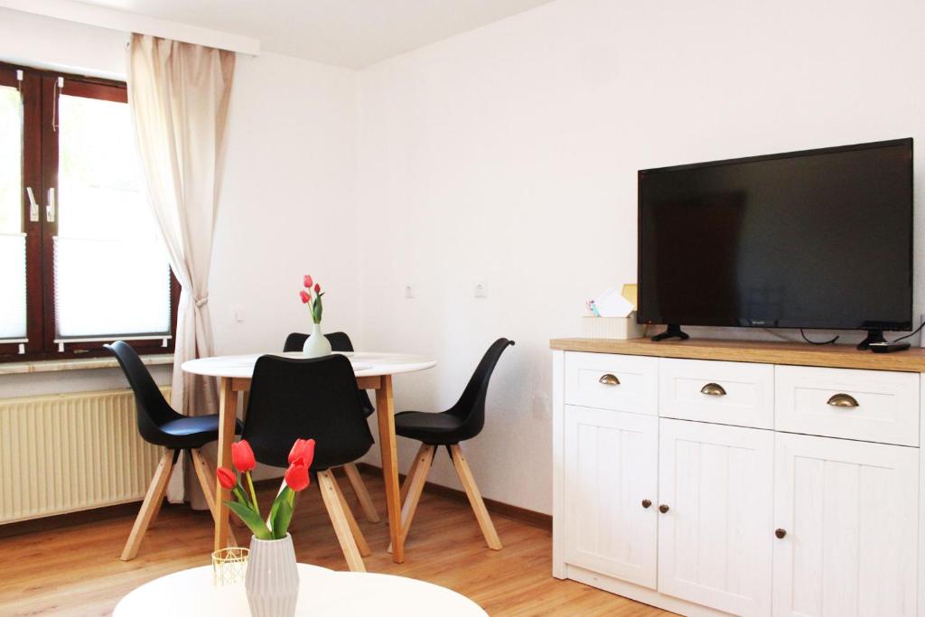 a living room with a table and a flat screen tv at Ferienwohnung im Rauchwinkel in Hösseringen