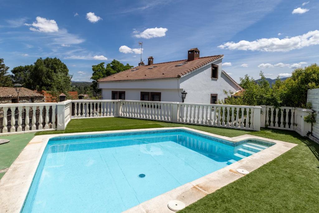 a swimming pool in the yard of a house at Casa Viria in Navaluenga