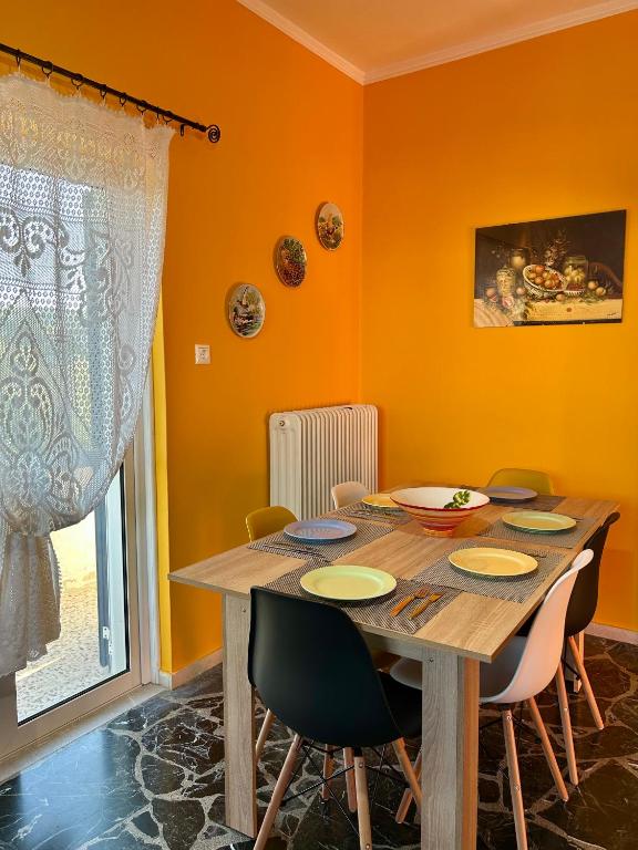 a dining room with a wooden table and chairs at Errant Blue House Kyllini in Kyllini