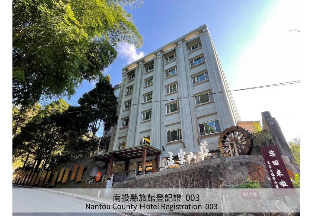 a large white building with a wheel in front of it at Ginkgo Hotel in Lugu Lake