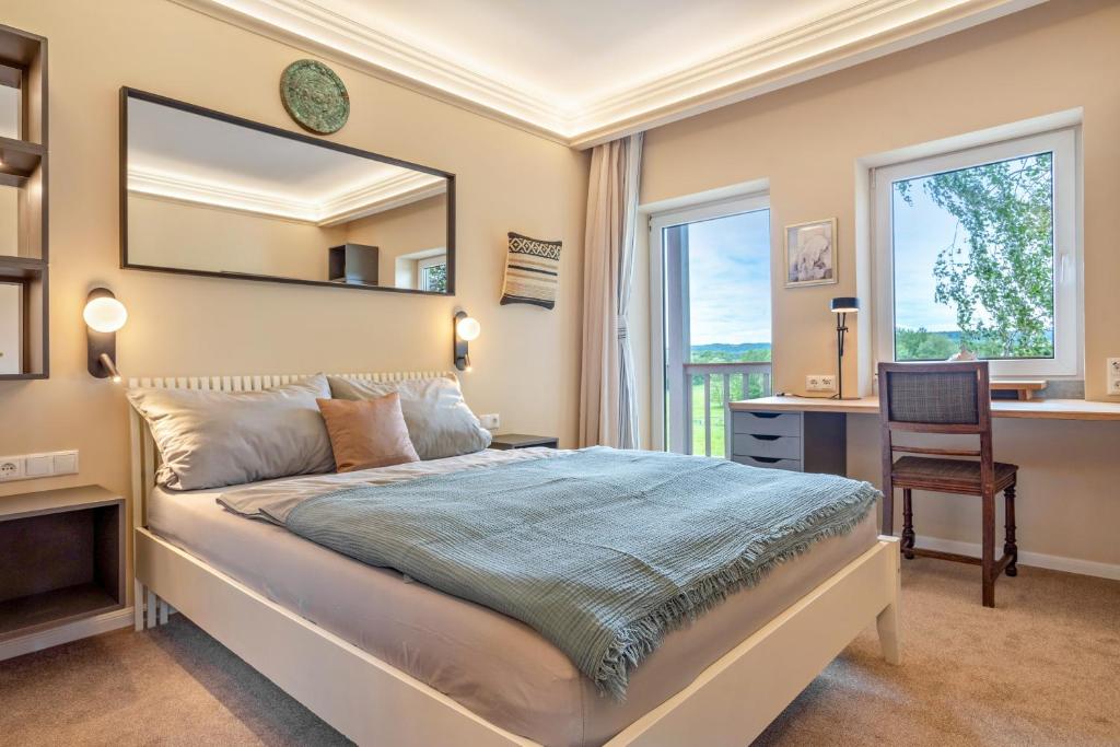 a bedroom with a bed and a desk and a mirror at Küstenblau - Fulgenhaus in Klein Bollhagen