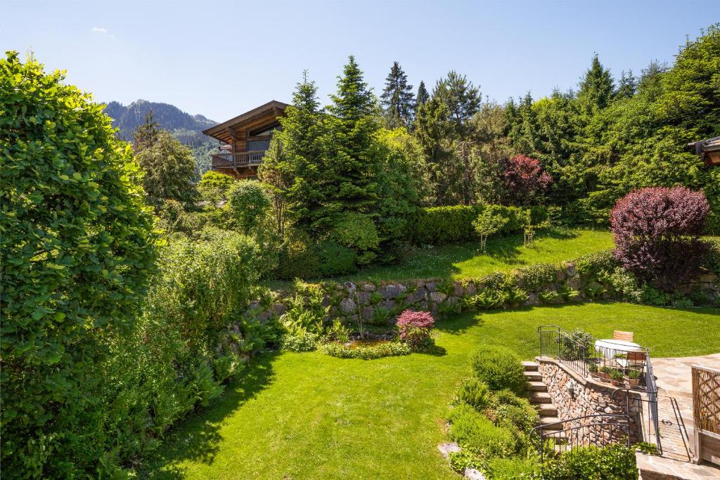 a garden with lush green grass and bushes at Chalet Lebenberg Kitzbühel in Kitzbühel