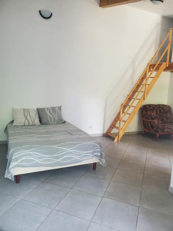 a bedroom with a bed and a staircase in it at Tranquillité in Le Cheylard