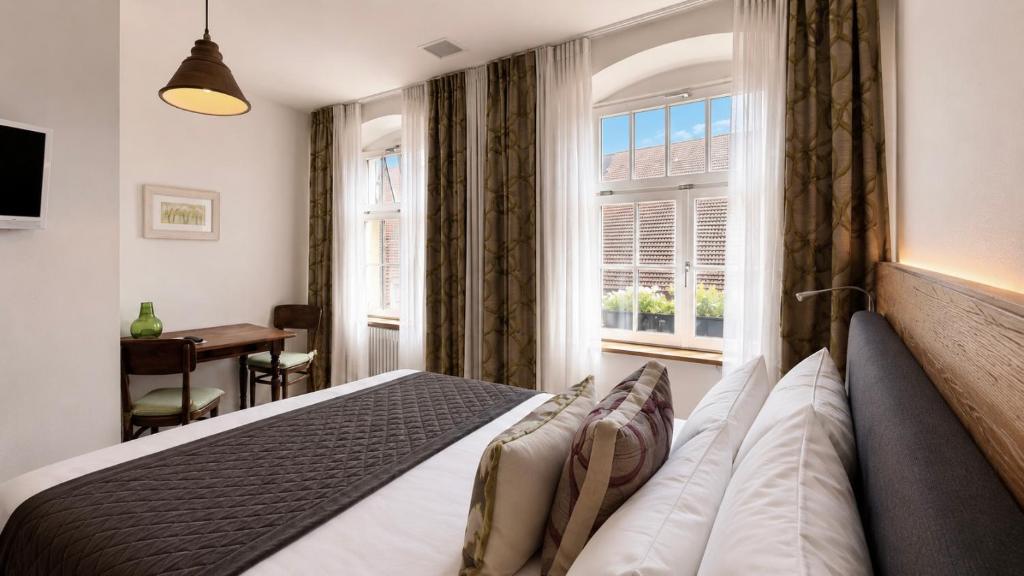 a bedroom with a bed and a window at Adler Oberdorf in Langenargen