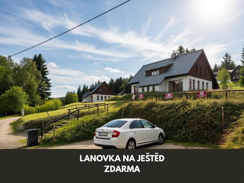 a white car parked in front of a house at Apartmány Severák Smrk in Janov nad Nisou
