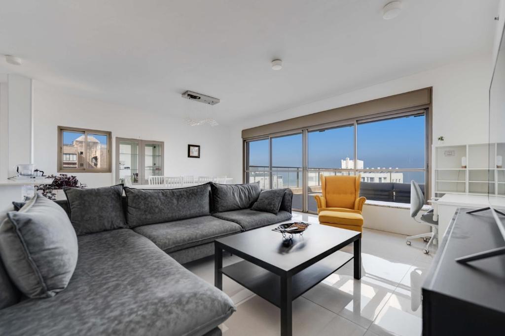 a living room with a couch and a table at Spacious Sea-View Penthouse + Big Balconies in Ashdod
