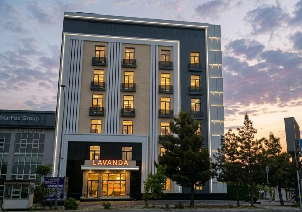 a building with a lit up sign in front of it at Lavanda hotel Tashkent in Tashkent