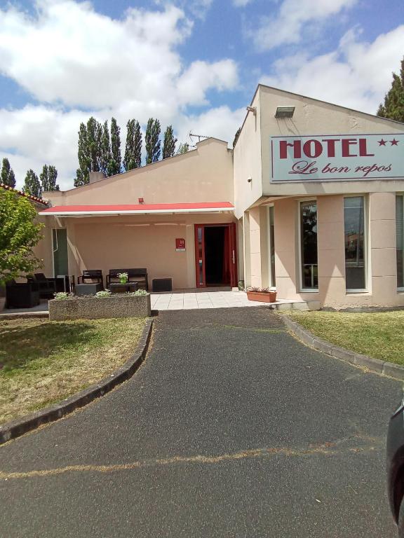 a hotel with a sign on the side of a building at Hôtel Bon Repos in Barbezieux-Saint-Hilaire