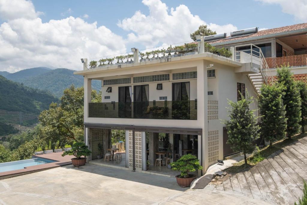 a large white house with a pool in front of it at Hillcrest Dawn, Bentong in Bentong