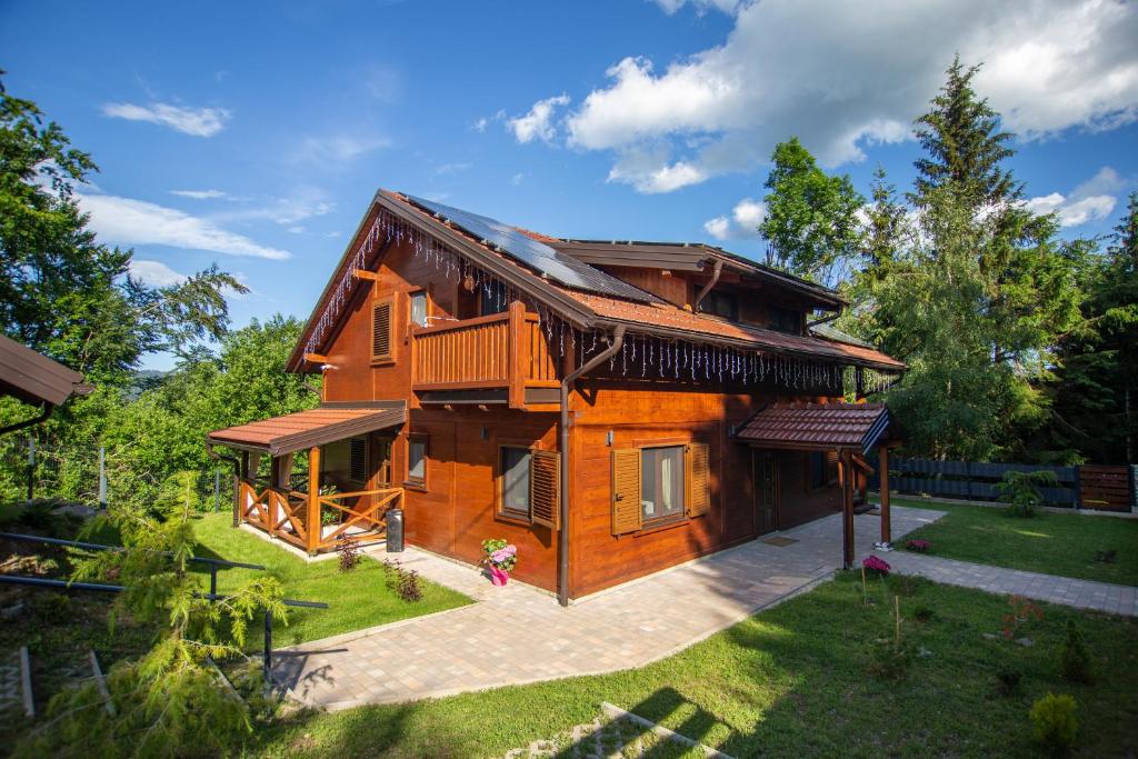 a log house with a porch and a yard at Macaklin Fužine in Fužine