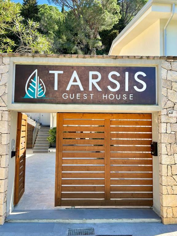 a garage door with a sign for a guest house at Tarsis Guest House in Baunei