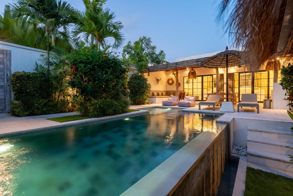 a swimming pool in the backyard of a house at Villa Ruta II - Luxury 2BR Tropical Villa next to Luna Beach Club and Nyanyi beach in Tanah Lot