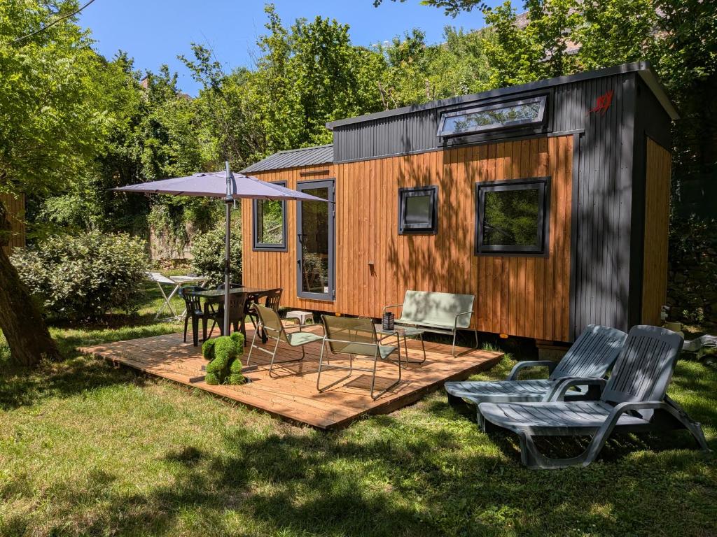 a tiny house with a table and chairs at Tiny house in Saint-Côme-dʼOlt