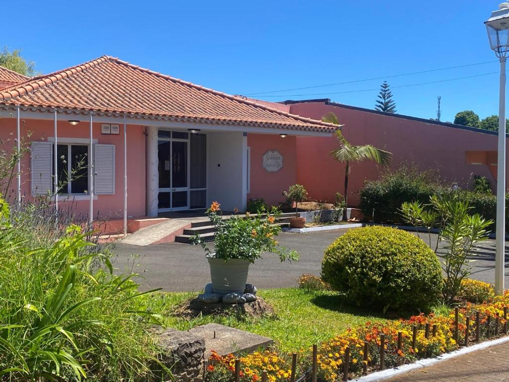 a house with a yard with flowers in front of it at Casa De Cha Prazeres in Prazeres