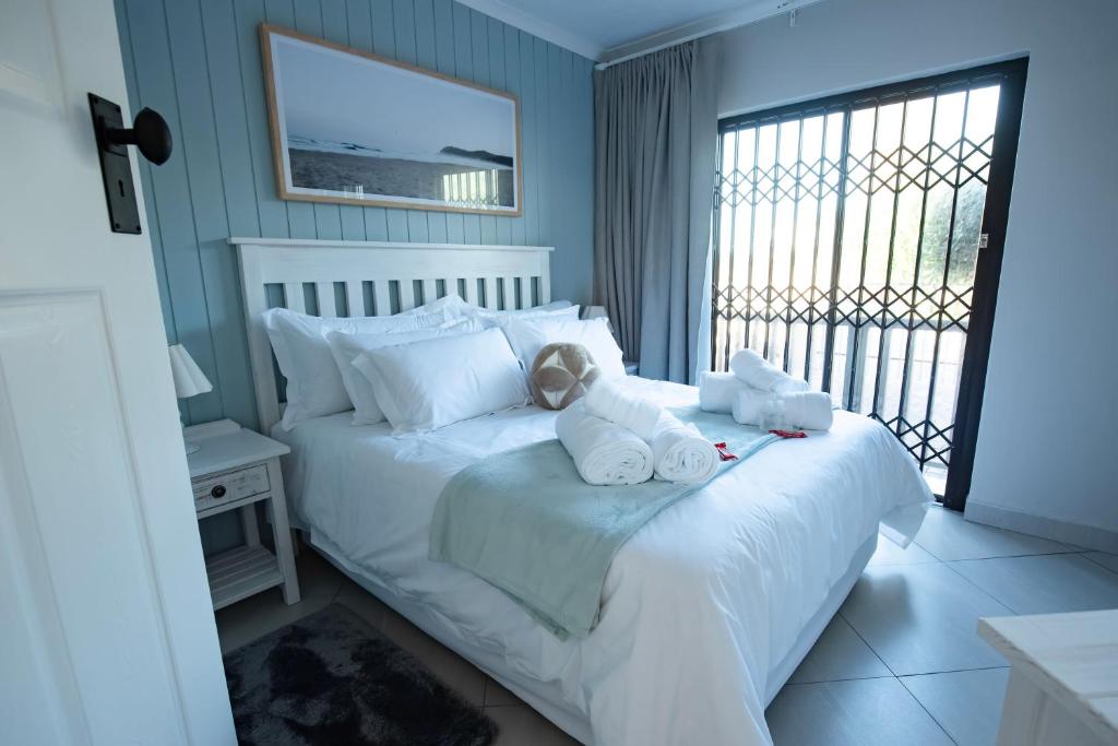 a bedroom with a bed with two stuffed animals on it at Oliverio Seaside Living in Sedgefield