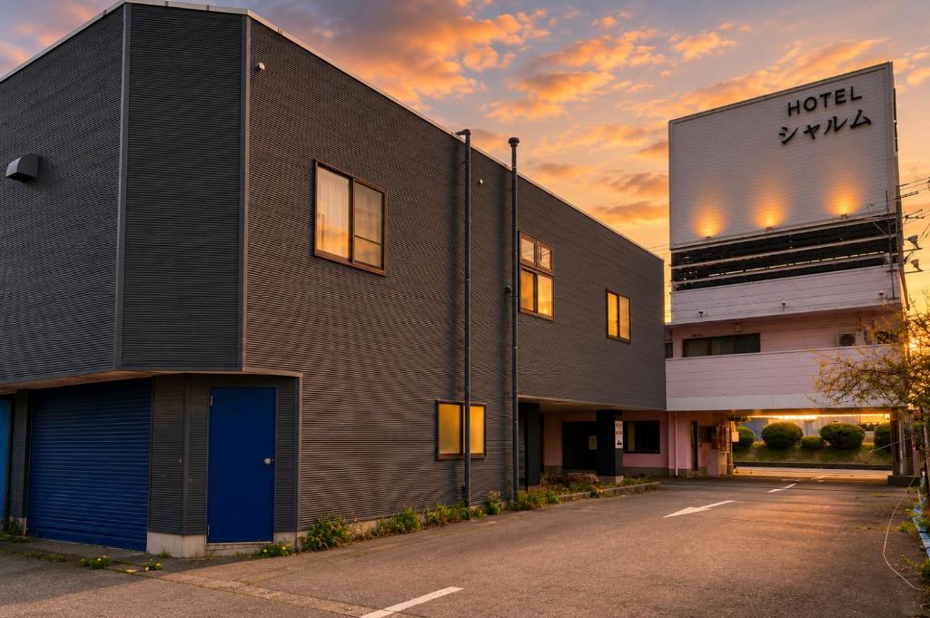 a building with the sunset in the background at adult only ホテルシャルム in Itoigawa
