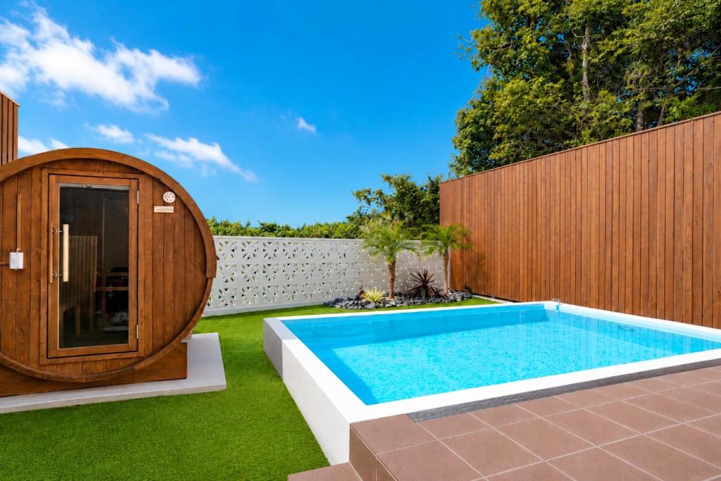 a swimming pool in a backyard with a wooden fence at Comlien Villa Resort in Tateyama
