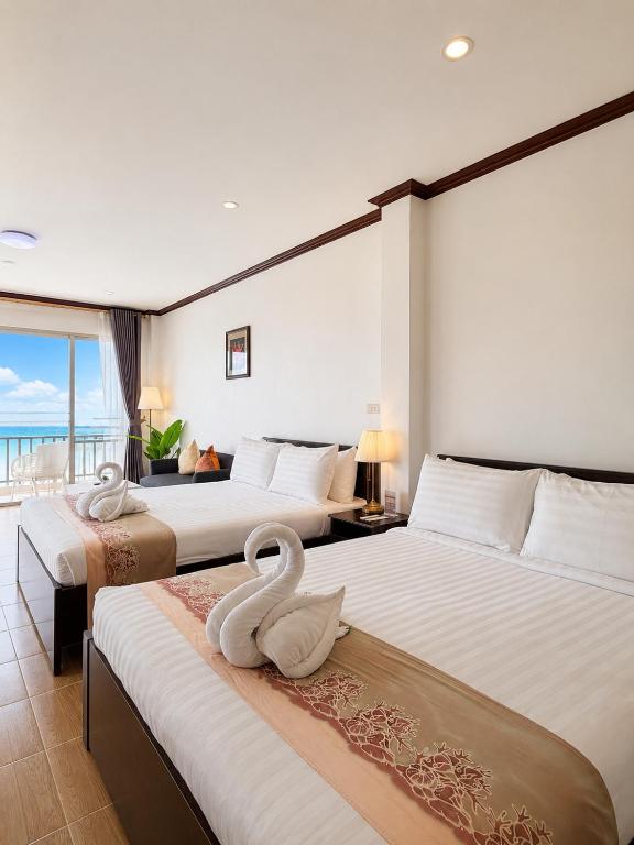 two beds in a hotel room with two swans on them at ClayHouse SAMUI Boutique Hotel in Koh Samui