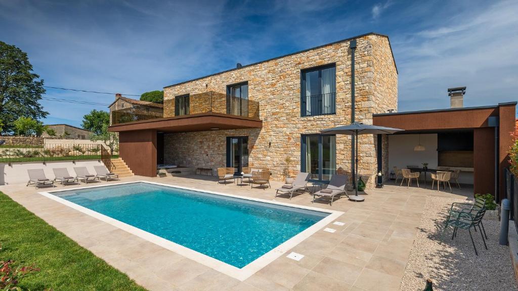 a house with a swimming pool in the backyard at Villa Moia by Villas Guide in Kaštelir